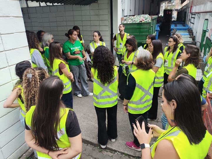 Participantes de coletes amarelos acompanham uma conversa durante visita técnica à Coopercaps